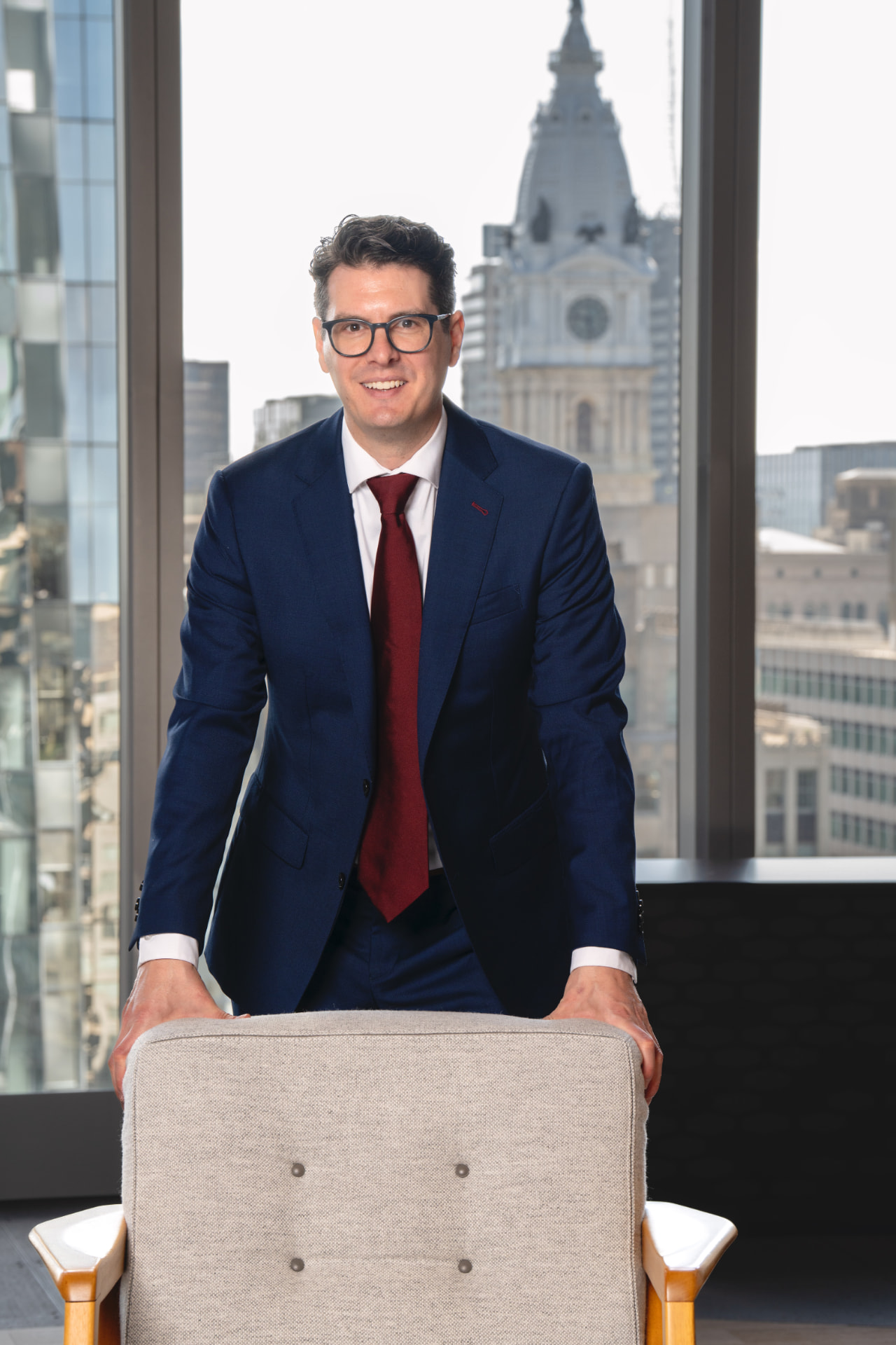Executive portrait in a high-rise office with the city skyline behind