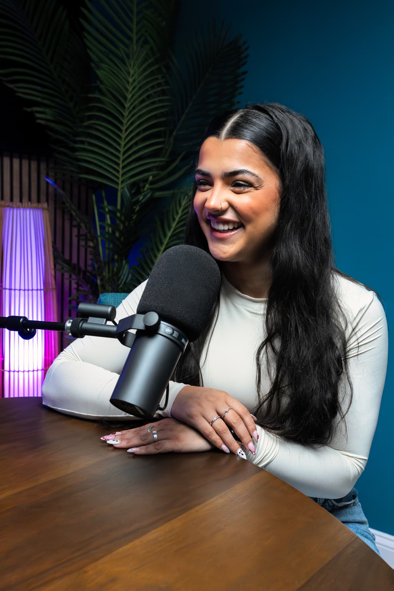 Podcast guest smiling behind a studio microphone