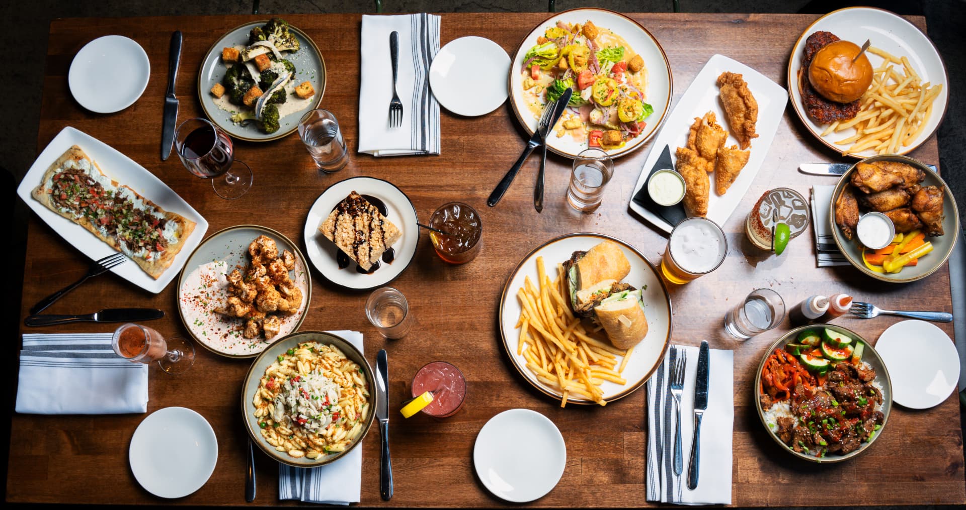 Overhead restaurant table arranged with a full menu of dishes and drinks